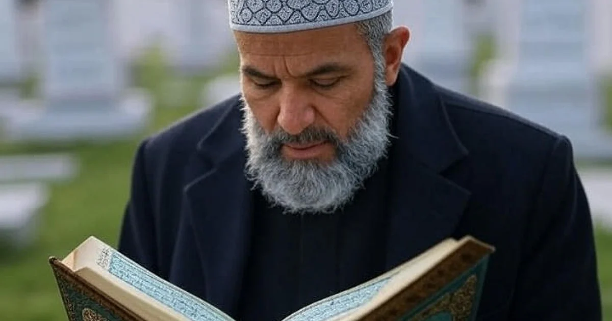 مرد مسلمانی در حال تلاوت قرآن در قبرستان با فضای معنوی و آرام