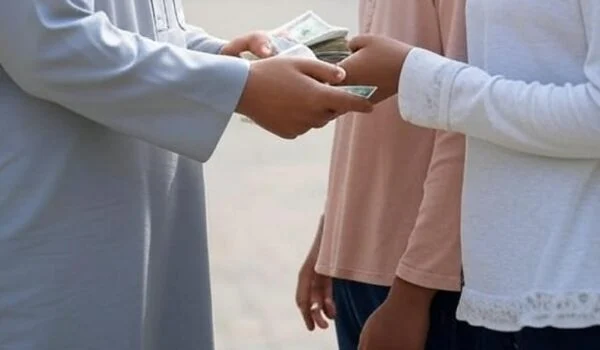 دست یک مرد مسلمان در حال پرداخت زکات به نیازمند