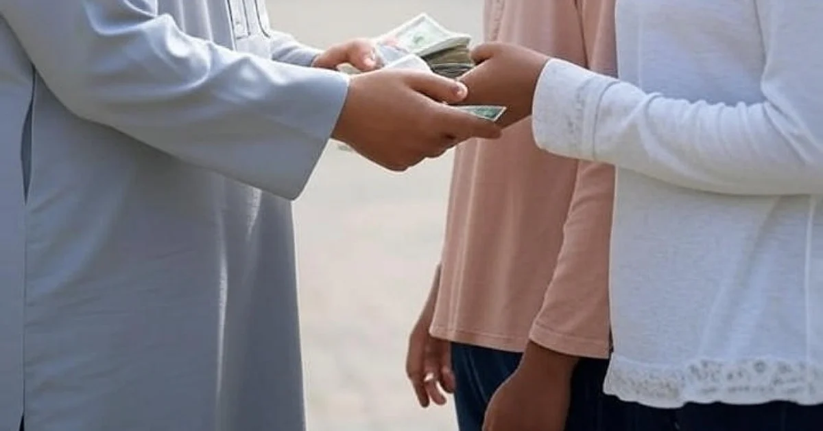 دست یک مرد مسلمان در حال پرداخت زکات به نیازمند